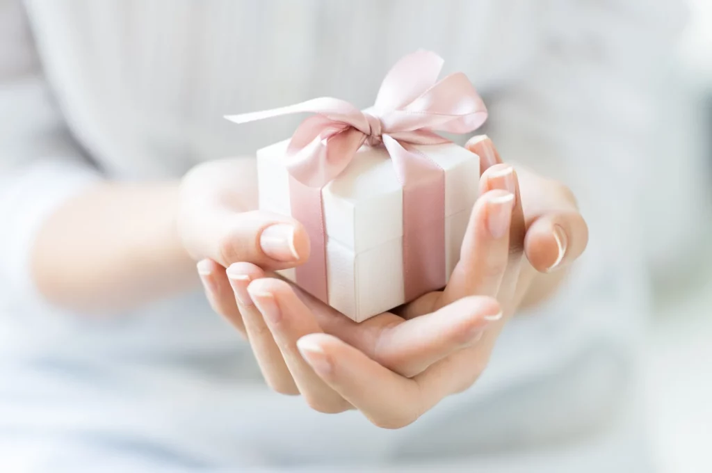 A Person hand holding a small gift box in Beverly Hills, CA | Maven Medispa
